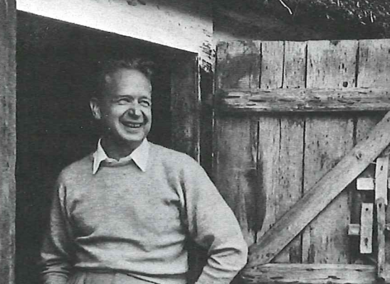 Dag Hammarskjöld standing in front of a barn.