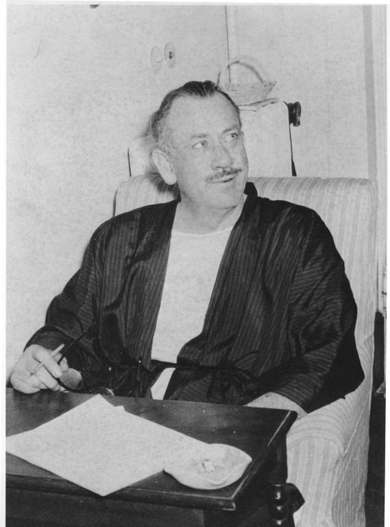 John Steinbeck sits at a writing desk while in Italy in 1957.